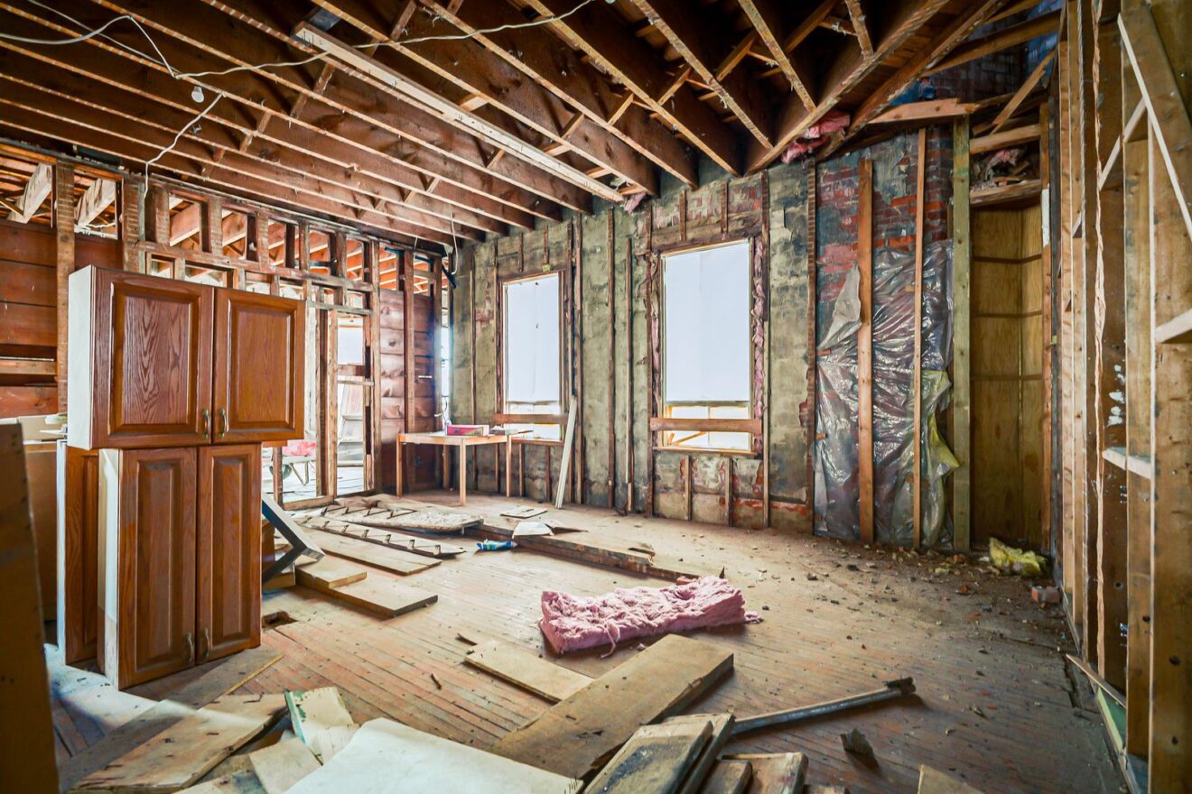 Gutted main floor interior with exposed studs, joists and brick