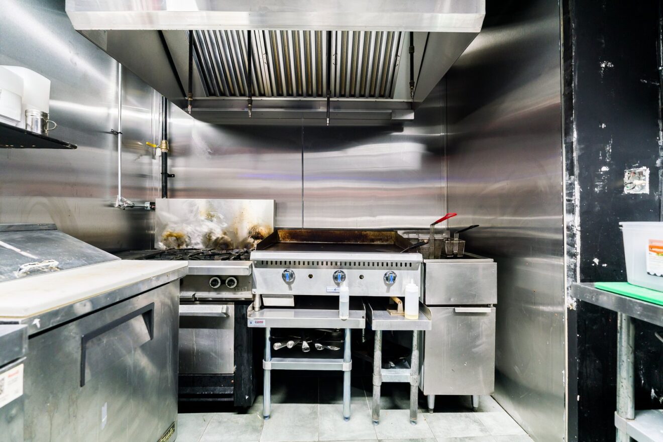 Commercial kitchen with exhaust hood and cooking line at 533 Bloor St W